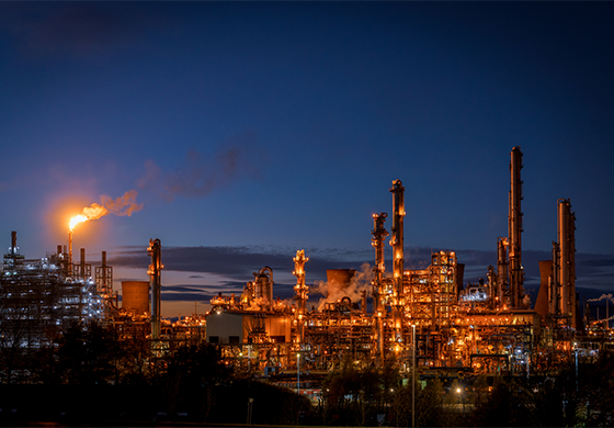 A UK factories cranes and infrastructure with a sunset behind it